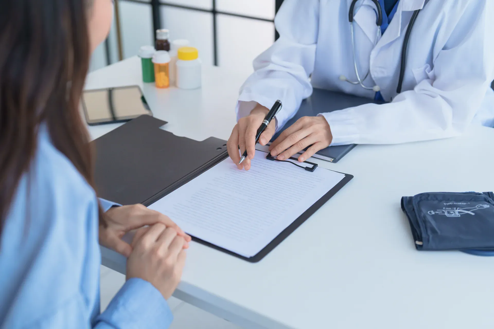 Patient completing new patient forms with provider