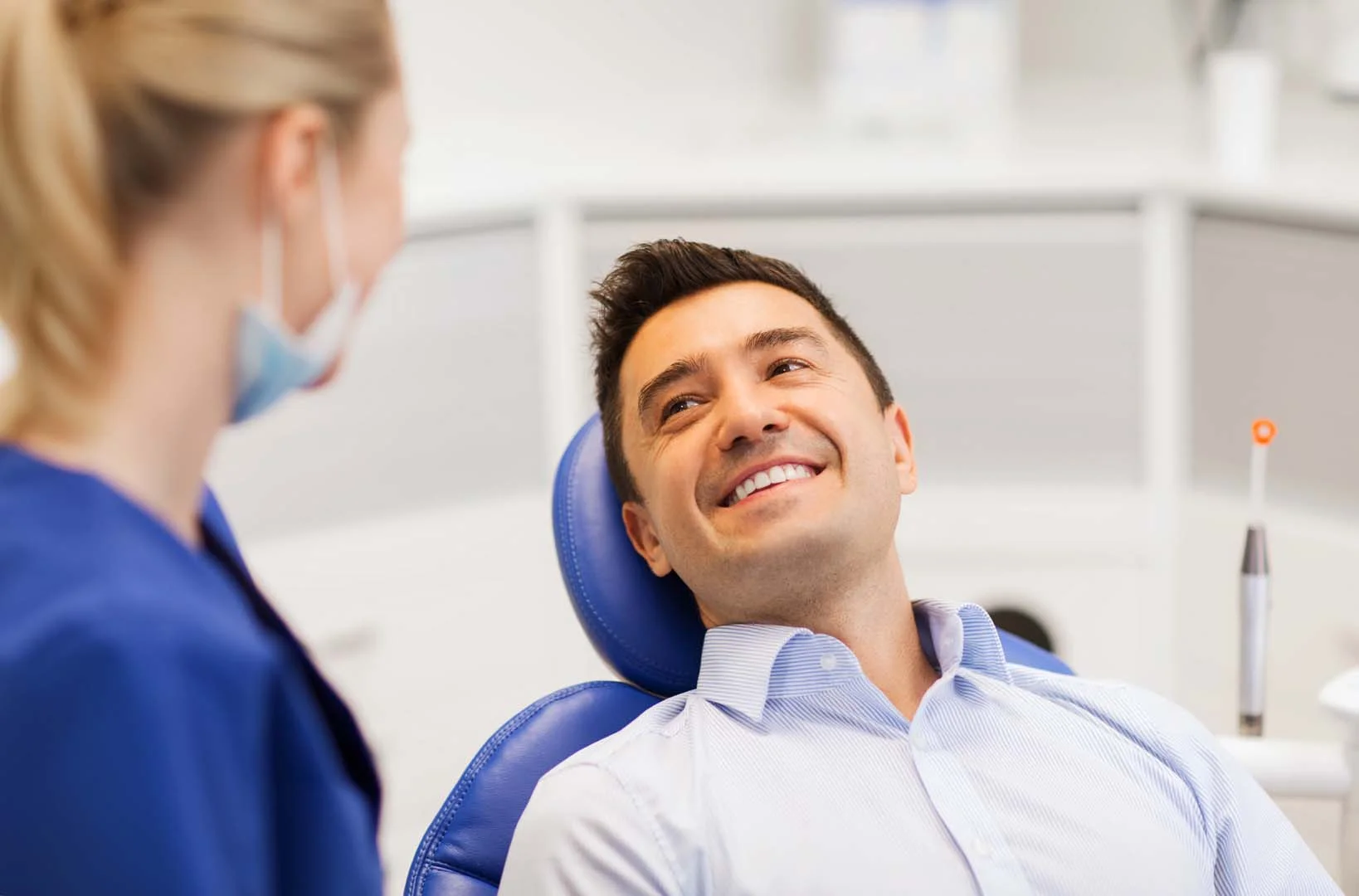 Smiling patient in the dental chair consulting with the oral surgery team
