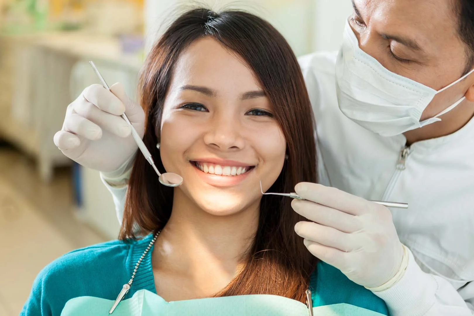 Dentist performing a preventive checkup for a smiling patient